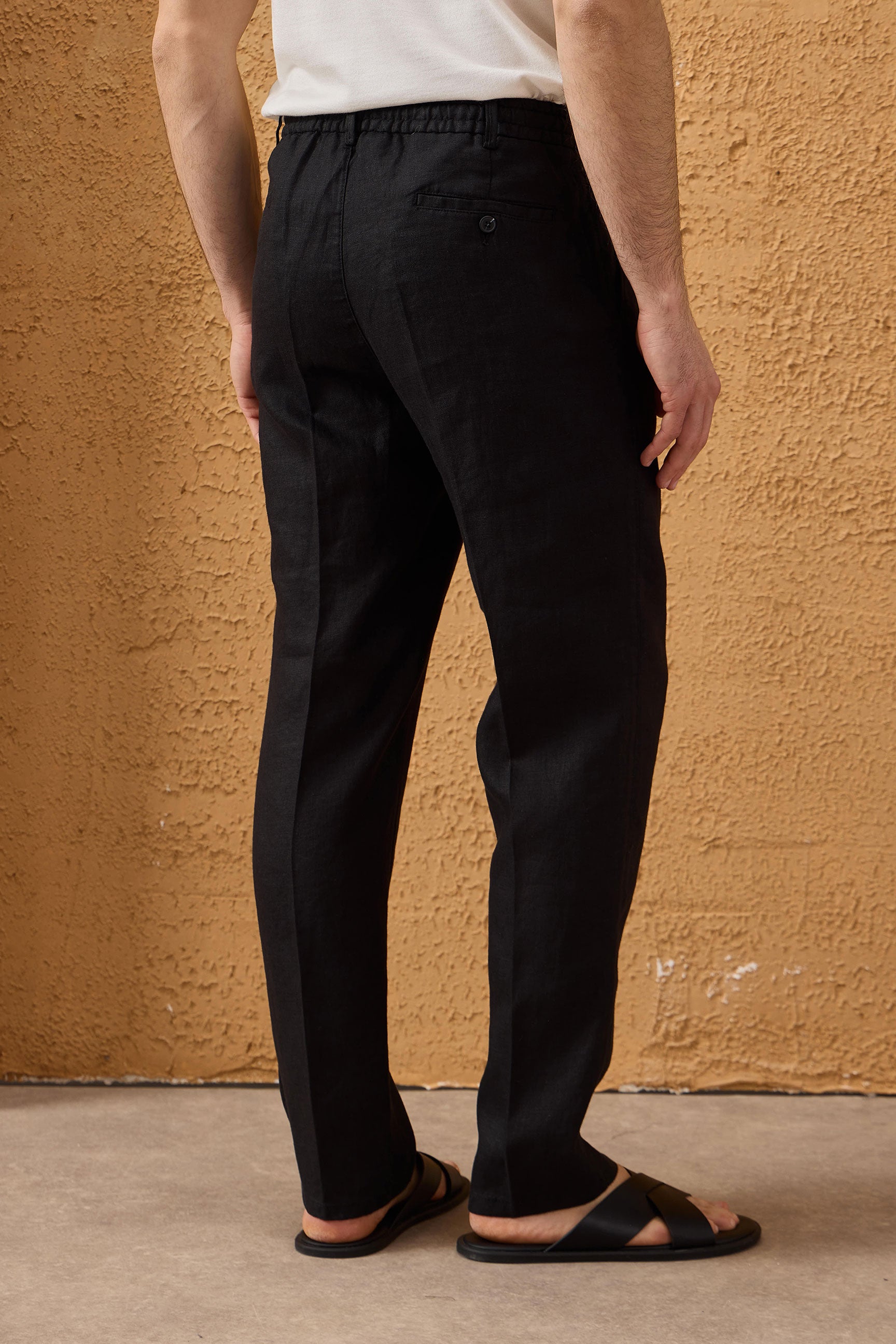Pantalon noir pour homme en lin 100 % avec cordon de serrage et plis, coupe droite décontractée.