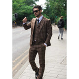 Man in a brown suit walking on a city street
