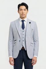 Homme portant un blazer gris clair, un gilet bleu marine et une cravate bleu foncé sur fond blanc
