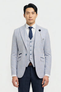 Homme portant un blazer gris clair, un gilet bleu marine et une cravate bleu foncé sur fond blanc