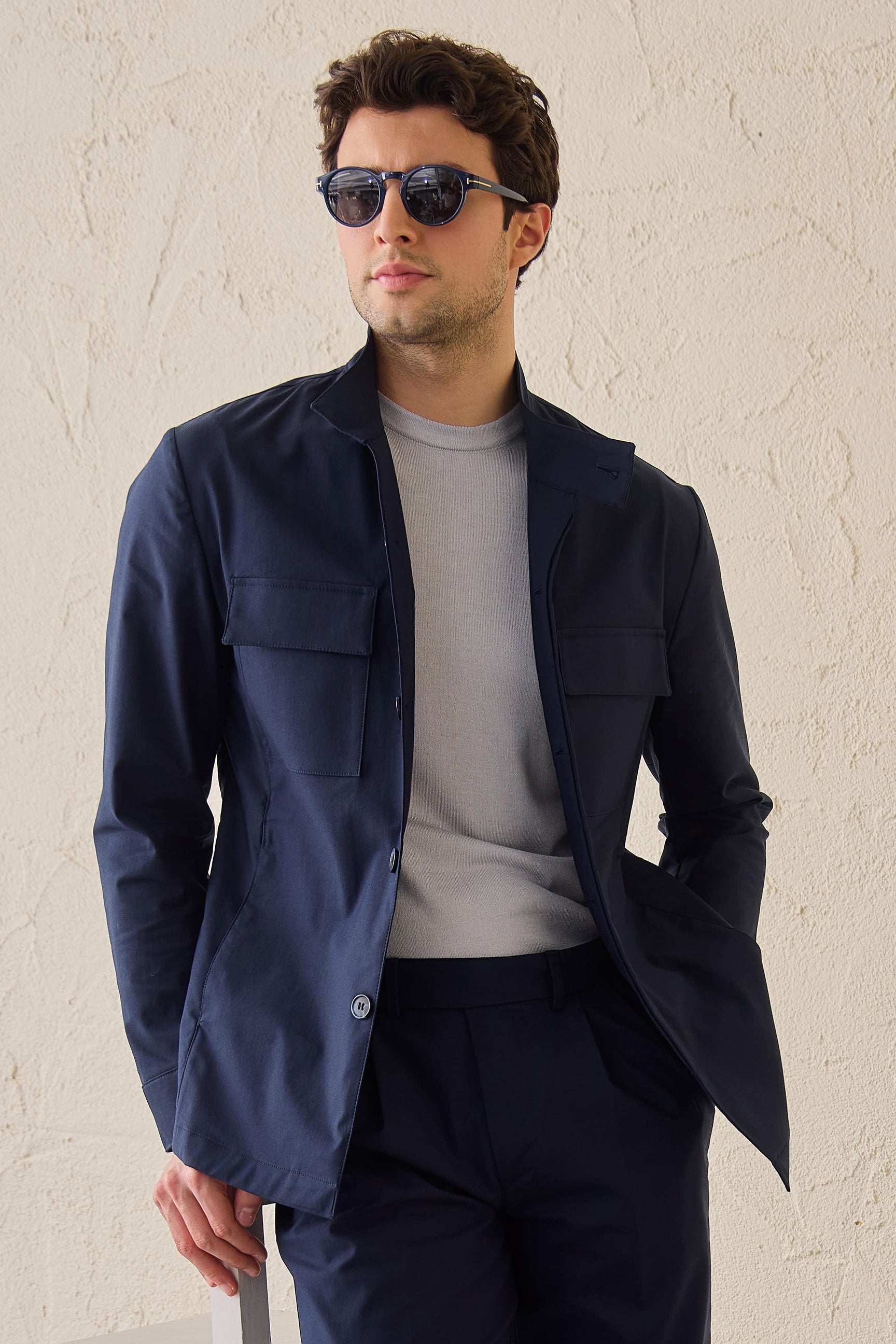 Costume deux pièces bleu marine pour homme, style safari, col montant, coupe élégante et décontractée.