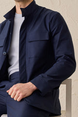 Costume deux pièces bleu marine pour homme, style safari, col montant, coupe élégante et décontractée.