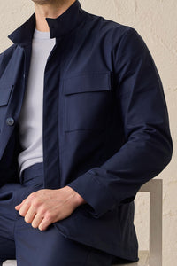 Costume deux pièces bleu marine pour homme, style safari, col montant, coupe élégante et décontractée.