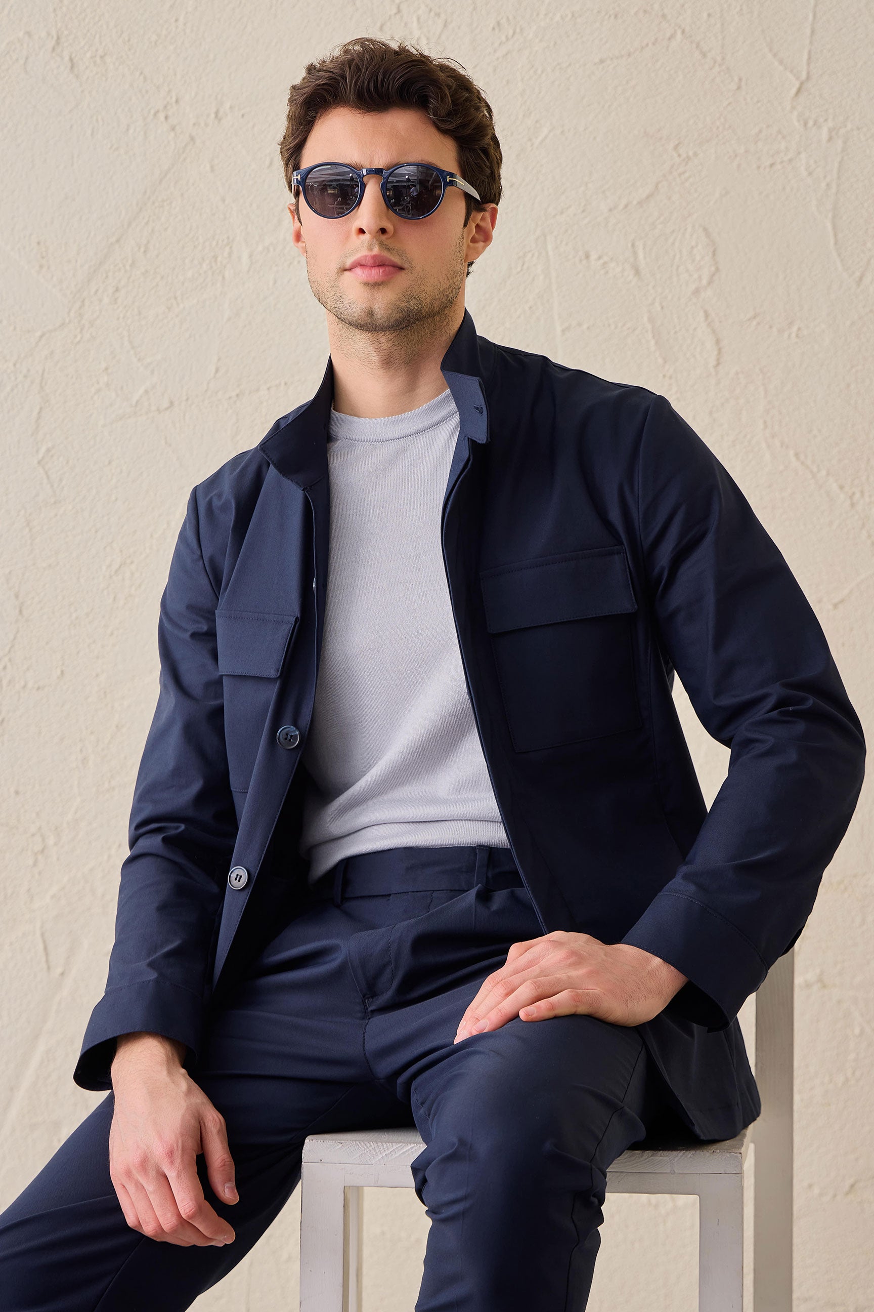 Costume deux pièces bleu marine pour homme, style safari, col montant, coupe élégante et décontractée.