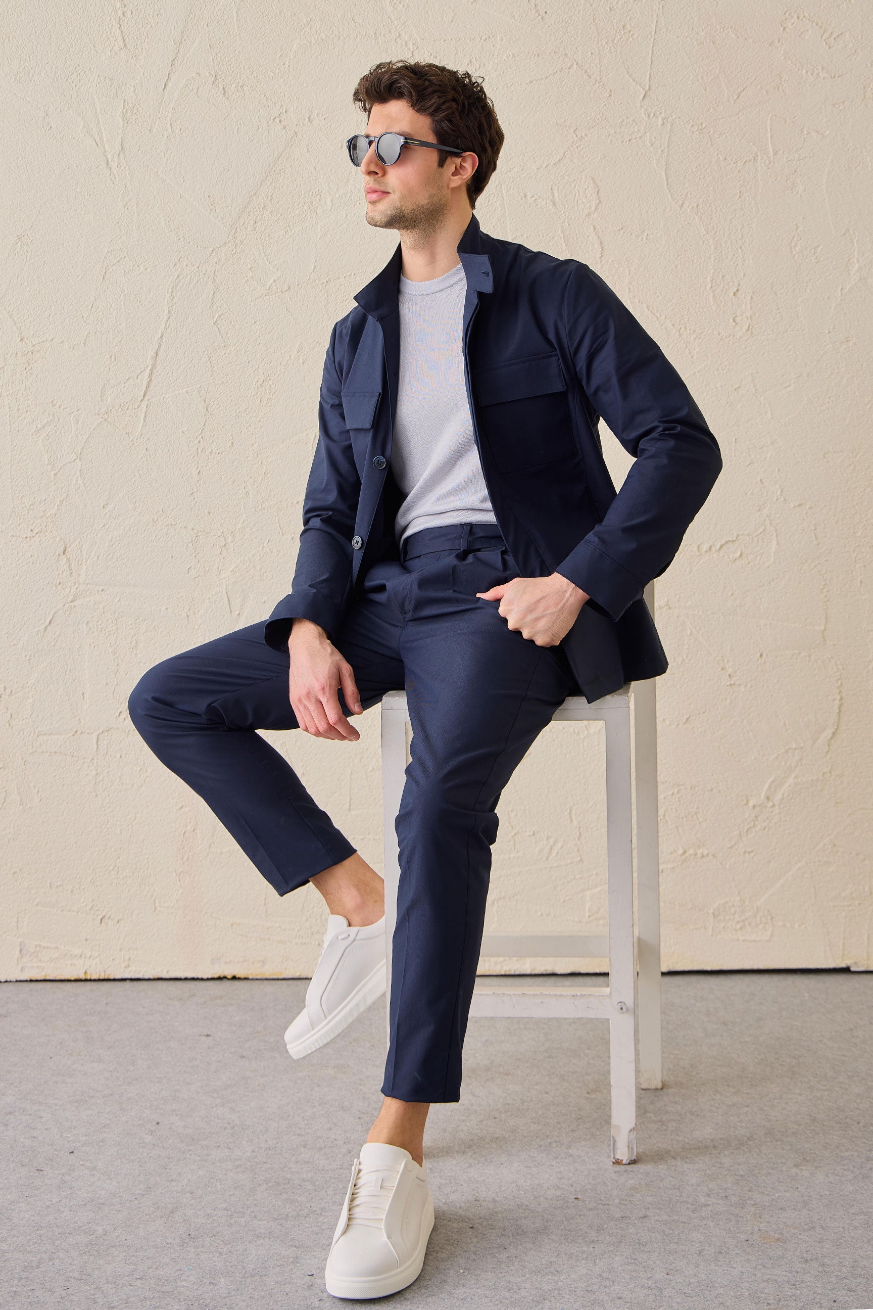 Costume deux pièces bleu marine pour homme, style safari, col montant, coupe élégante et décontractée.