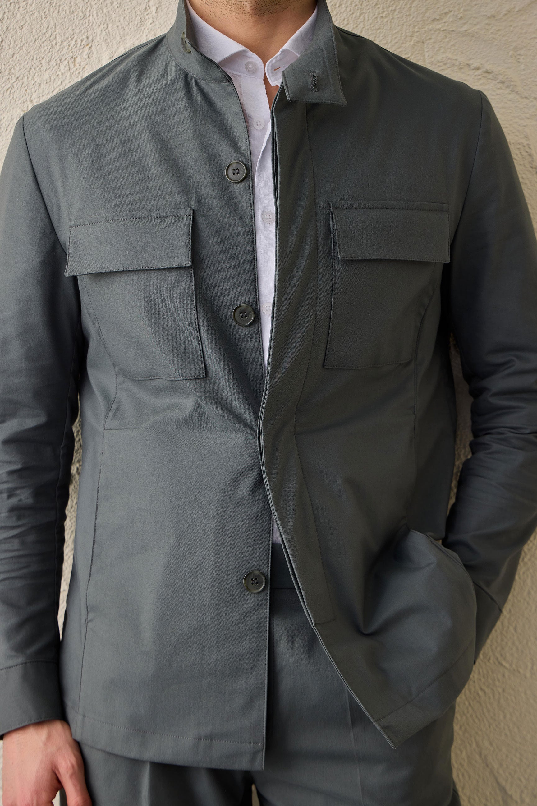 Costume deux pièces pour homme, vert sauge, style safari, col montant, coupe élégante et décontractée.