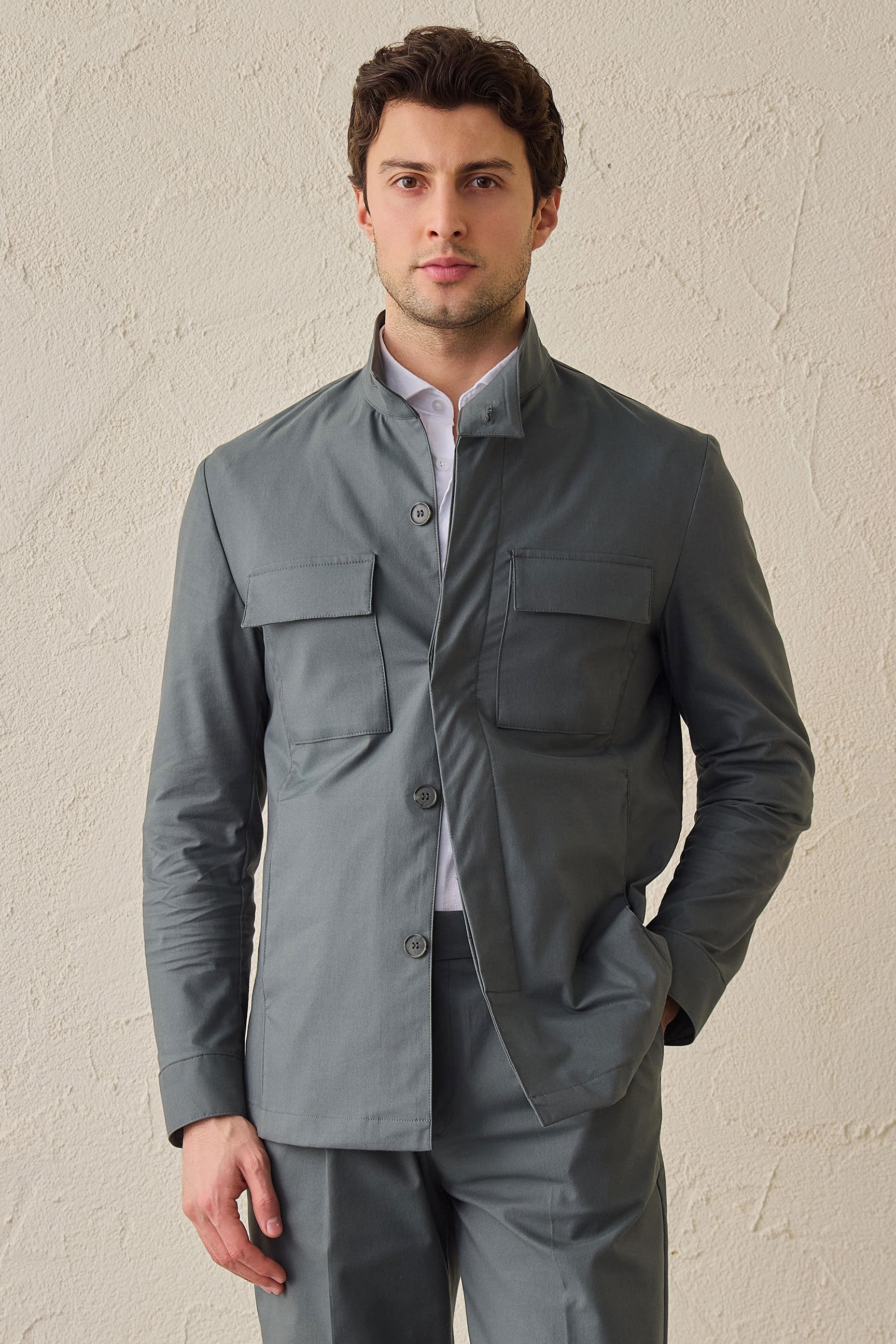 Costume deux pièces pour homme, vert sauge, style safari, col montant, coupe élégante et décontractée.