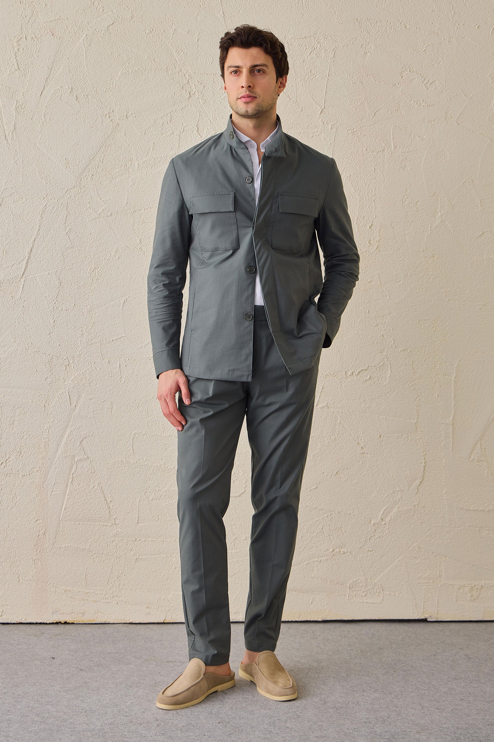 Costume deux pièces pour homme, vert sauge, style safari, col montant, coupe élégante et décontractée.