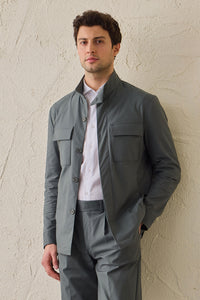 Costume deux pièces pour homme, vert sauge, style safari, col montant, coupe élégante et décontractée.