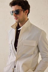 Costume deux pièces blanc pour homme, style safari, col montant, coupe élégante et décontractée.