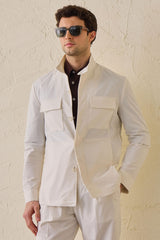 Costume deux pièces blanc pour homme, style safari, col montant, coupe élégante et décontractée.