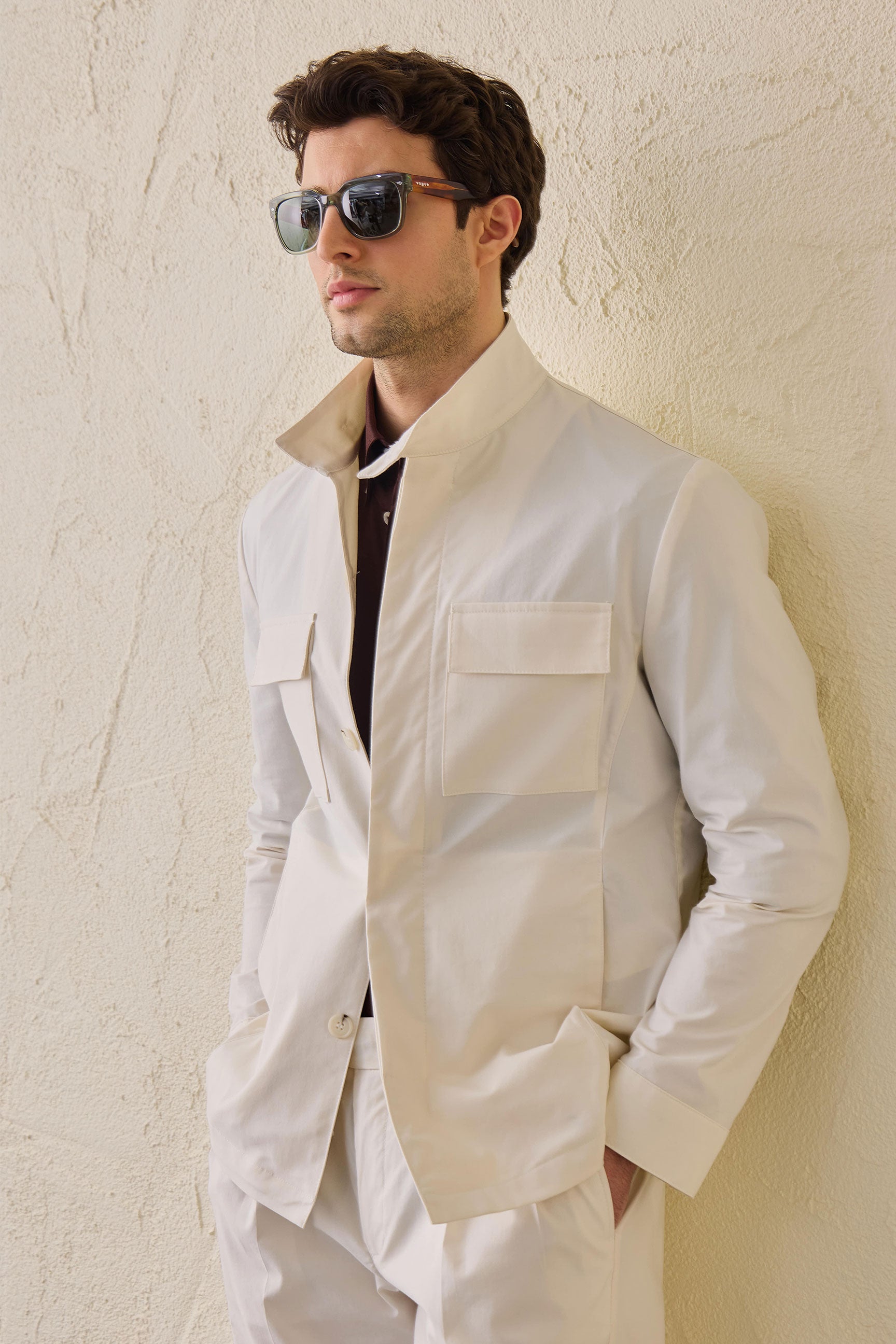 Costume deux pièces blanc pour homme, style safari, col montant, coupe élégante et décontractée.